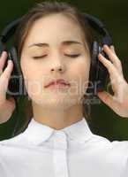 The allure of the rhythm. Shot of a young woman listening to music in the park.