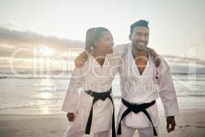 Theyre a kickass karate couple. Shot of two young martial artists practicing karate on the beach.