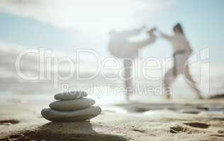 The mind of a fighter should always be calm and calculated. Full length shot of two unrecognizable martial artists practicing karate on the beach.