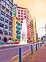 Blurred colorful city street at sunset. Artistic concept of an urban town with cars parked near office buildings and a yellow sky. Low angle view of futuristic abstract architecture with sun flare