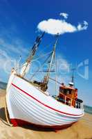 Beautiful landscape of a white fishing boat parked at the beach on a sunny day. Fishing boat on a sandy beach. A local fishing boat moored at the shore on a beautiful bright wooden boat on the beach