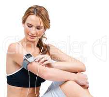 Driven by the music - Fitness Health. A fit young woman adjusting an mp3 player attached to her arm while taking a quick breather.