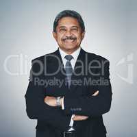 His leadership qualities far surpasses all. Studio portrait of a mature businessman posing against a grey background.