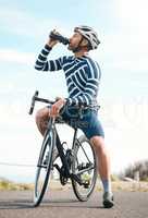 Staying properly hydrated. Full length shot of a handsome mature man taking a water break while cycling outdoors.