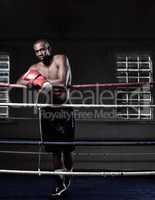 Masculine African American boxer. Full length of handsome African American male boxer standing near ring.
