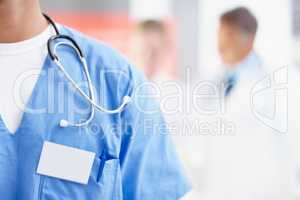 Markings of a medical professional. Cropped image of a male surgeon wearing a nametag alongside copyspace.