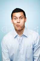 Be silly while you can. Shot of a young man making facial expressions against a studio background.