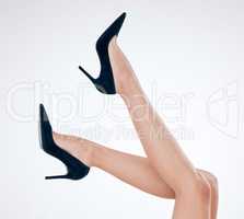 Closeup of unrecognizable woman posing against a white studio background. One female only feeling confident while showing her hairless, smooth legs after hair removal or epilation