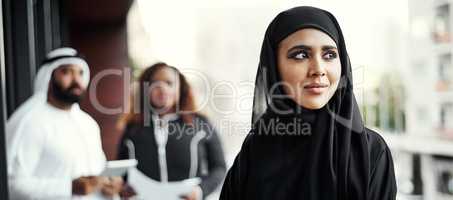 Shes full of ideas. an attractive young businesswoman dressed in Islamic traditional clothing standing on her office balcony.