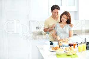 The most important meal of the day. Young pregnant woman preparing food in the kitchen with her husband.