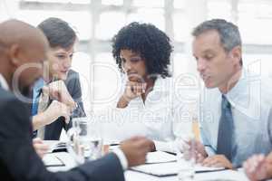 Detailed deliberations. A diverse group of business people going over facts and figures during a meeting.