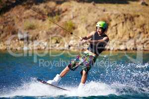 Awake on the wake. Young wakeboarder sliding out on his back foot - copyspace.