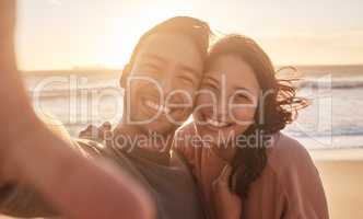 Portrait of a young diverse biracial couple taking a selfie at the beach and having fun outside. Portrait of a young diverse biracial couple taking a selfie at the beach and having fun outside.