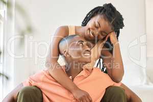 Young happy carefree and cheerful african american couple bonding and enjoying relaxing time together at home. Loving black female smiling while hugging and looking at her boyfriend sitting together