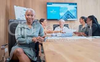 Confident, powerful african american businesswoman in a meeting with her colleagues holding a wireless tablet. Young business professional in her office with her colleagues in collaborating