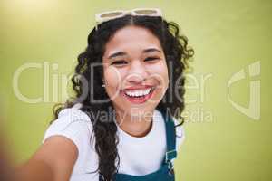 Closeup beautiful mixed race fashion woman taking selfies pictures against a lime green wall background in the city. Young happy hispanic woman looking stylish, trendy. Carefree and fashionable
