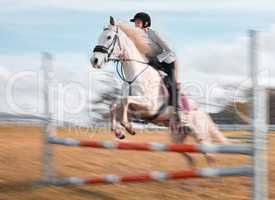 Once you build trust, you will soar. a young rider jumping over a hurdle on her horse.