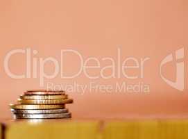 Stack of coins isolated against a brown background. Concept of money saving, investment, finance, currency and wealth. Costs increase with inflation in the economy. Budget your income for retirement