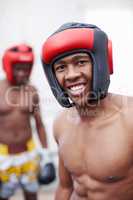 African American male boxer smiling. Portrait of African American male boxer smiling with competitor standing in background.