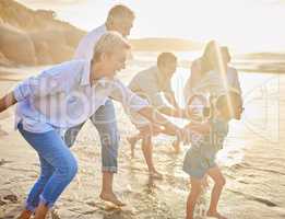 Multi generation family holding hands and walking along the beach together. Caucasian family with two children, two parents and grandparents enjoying summer vacation