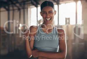 I hope you have a smashing session today. Portrait of a sporty young woman winking while showing thumbs up in a gym.