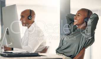 Young african american call centre telemarketing agent enjoying a break to stretch and rest with hands behind head while working in an office. Female consultant feeling satisfied once done completing deadlines and reaching successful sales target