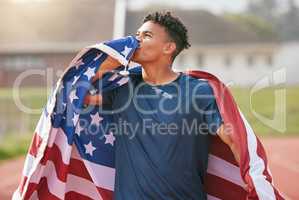 This ones for you, America. a handsome young male athlete kissing his flag while celebrating a victory for his country.
