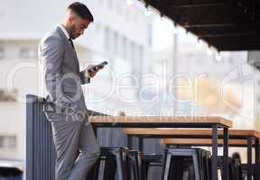 Waiting to be seated. a handsome young businessman checking his messages while waiting to be seated at an internet cafe in the city.