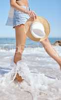 One beautiful young caucasian woman relaxing on the beach. Enjoying a summer vacation or holiday outdoors during summer. Taking time off and getting away from it all. Spending the day alone outside