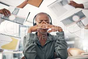 Anxious young african american call centre telemarketing agent feeling pressure and headache while working in demanding busy office environment. Overworked and exhausted consultant trying to multitask deadlines. Mentally frustrated with burnout and stress