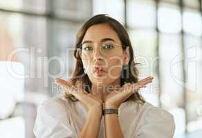 Funny business woman with glasses posing with her hands under her face and making fish face grimace with pout lips in an office. Playful hispanic female entrepreneur fooling and and being silly