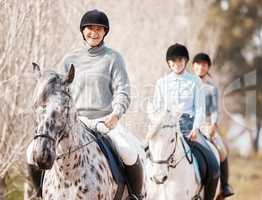 A good horse is hard to replace. Shot of three attractive young women horse riding on a farm.