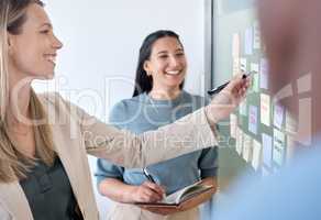 Crafty, I like this. Shot of a group of businesspeople brainstorming with sticky notes on a chalkboard.