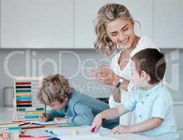 Single mother teaching little sons during homeschool class at home. Autistic cute little caucasian boys learning how to read and write while their single parent clap to motivate and support them