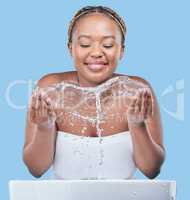 Your skin will always need moisture. Studio shot of an attractive young woman washing her face against a blue background.