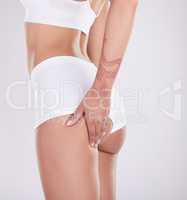 Those squats got rid of all my cellulite. an unrecognisable woman standing and posing in her underwear in the studio.