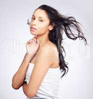 I love hair that goes with the flow. Shot of a young woman posing against a white background with healthy looking hair.