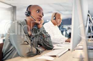 Stressed african american call centre telemarketing agent looking bored and anxious while working on broken computer in an office. Worried female consultant having problems with slow internet connection error. Lazy employee struggling with difficult calle