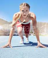 Serious female athlete at the starting line in a track race competition at the stadium. Fit sportswoman mentally and physically prepared to start running at the sprint line or starting block