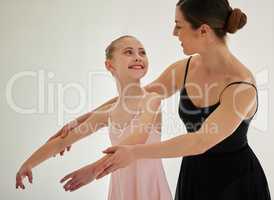 Developing self-confidence and pride in herself. a young girl practicing ballet with her teacher in a dance studio.
