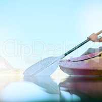 Closeup of kayak oar paddle rowing on calm water. Female hands kayaking on a lake during summer break. Woman outside in nature enjoying water activity. Training and practicing for a kayak race