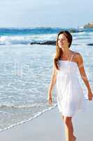 Beautiful young woman walking on beach. Portrait of a beautiful young woman walking on the sea shore.