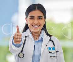 Portrait shot of a young happy mixed race doctor showing a thumbs while working alone at a hospital. One happy pleased hispanic gp smiling and showing a thumb in support working at a clinic