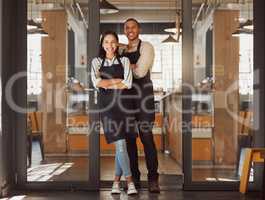 Proud business partners standing in their supermarket entrance. Business colleagues standing in their coffeeshop. Portrait of married couple working in cafe together. Colleagues arms crossed in shop