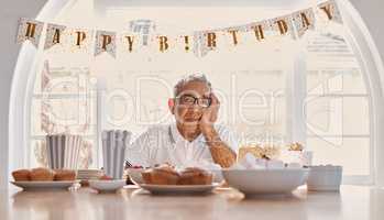 Loneliness is my least favorite thing about life. Shot of a senior man looking unhappy while celebrating his birthday alone at home.