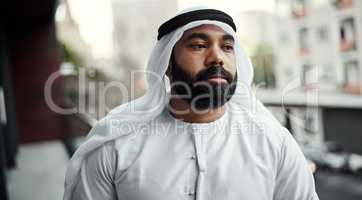 Some fresh air to fuel the mind. a businessman dressed in traditional Islamic clothing working on his office balcony.