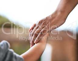 Hold my hand tightly. Shot of an unrecognizable parent and child holding hands at home.