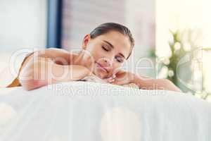 Spoil yourself today. a beautiful young woman lying on a massage table at the day spa.