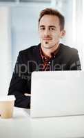 Ive worked hard for the rewards Im reaping now. Portrait of a young businessman working on a laptop in an office.