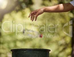 One unknown mixed race woman throwing a plastic bottle in a bin to conserve the planet earth and recycle. Hispanic woman choosing to toss litter in the trashcan. Protect the environment, keep clean